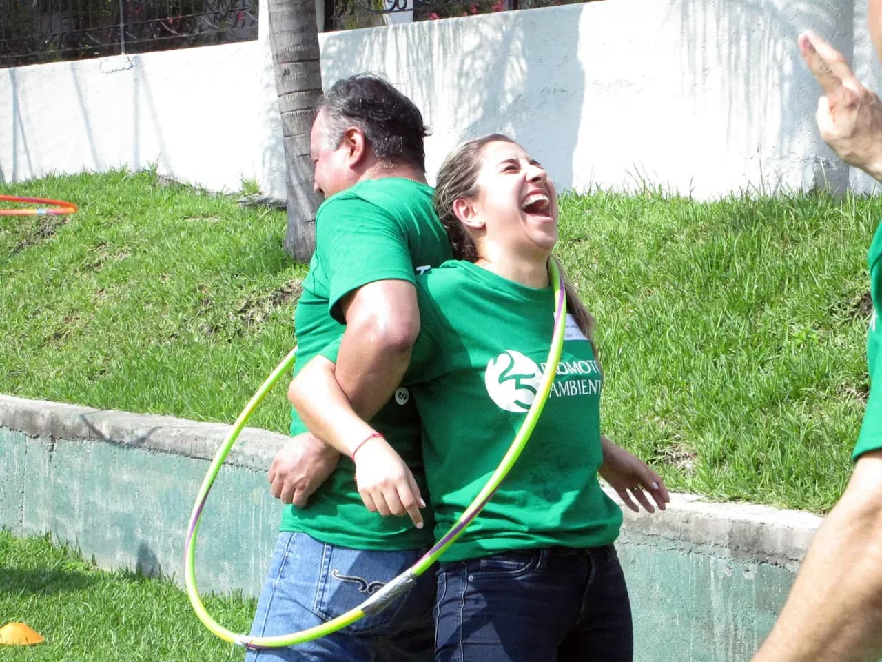 Participantes colaborando en una dinámica grupal al aire libre, fortaleciendo la confianza y el trabajo conjunto