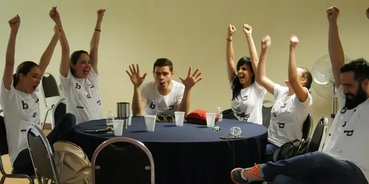 Dos participantes mostrando alegría y creatividad durante una dinámica grupal del rally empresarial