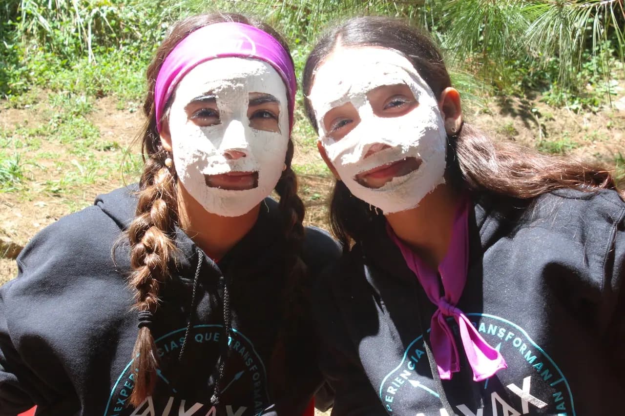 Dos campistas sonríen con mascarillas blancas en la cara