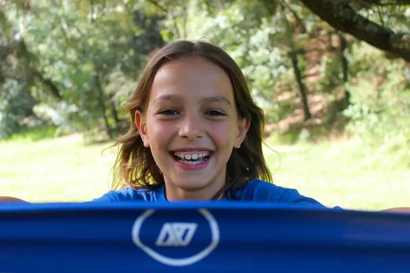 Niña sonriendo de cerca durante una actividad del campamento