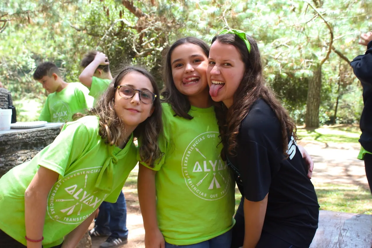Tres amigas del campamento abrazadas, una saca la lengua