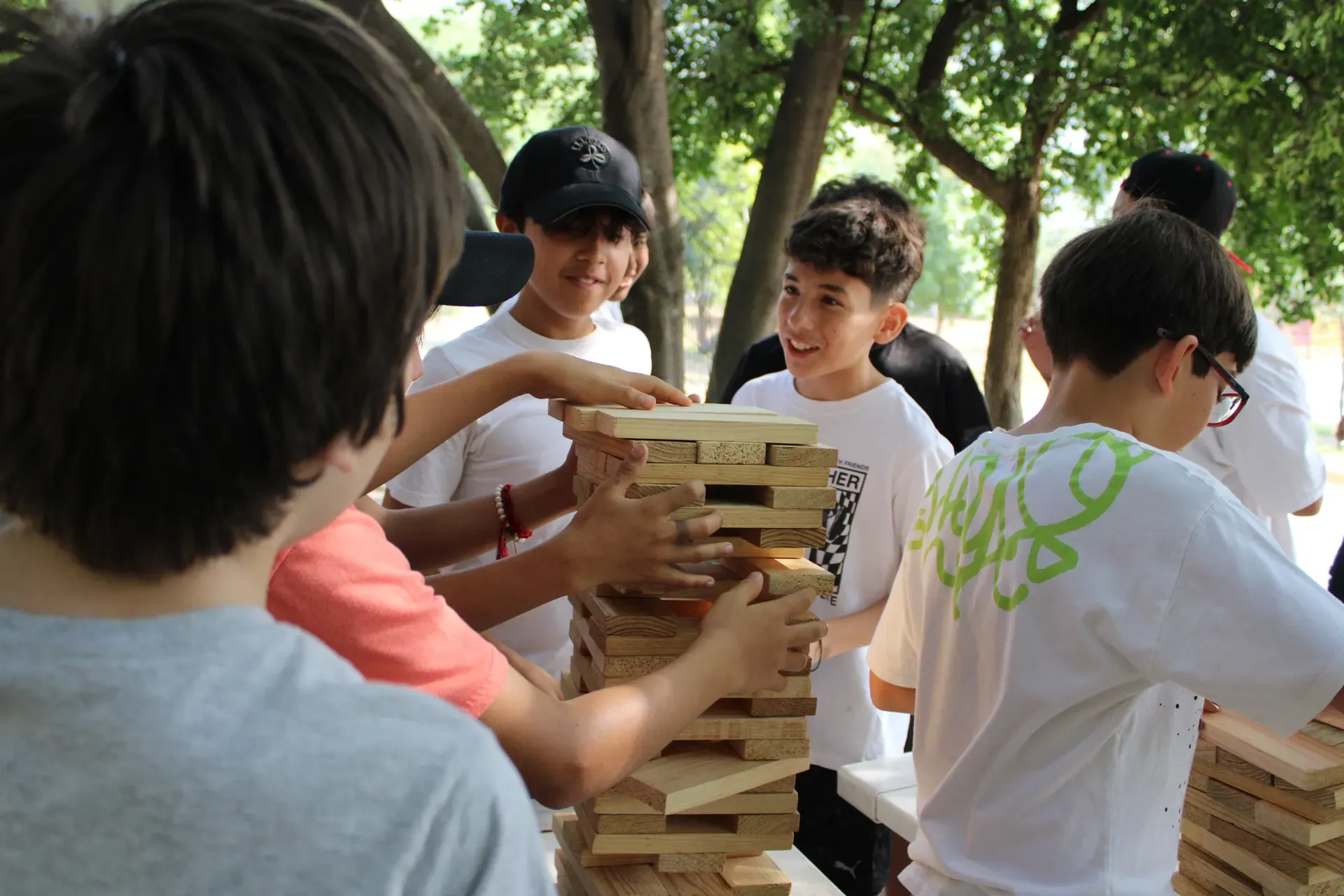 Campistas construyendo juntos una torre de bloques de madera