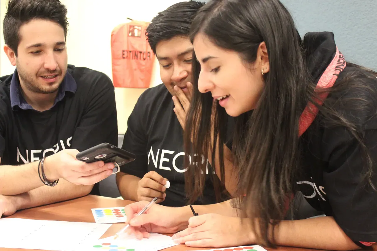 Momento de concentración mientras un grupo de asistentes trabaja en equipo para resolver un desafío práctico
