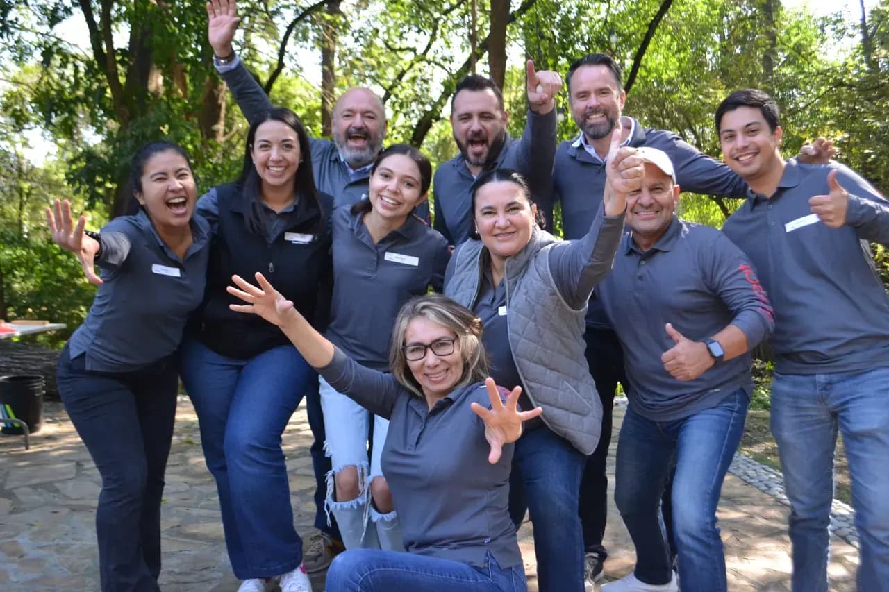 Grupo celebrando al final de una actividad, mostrando el impacto positivo de las dinámicas de liderazgo