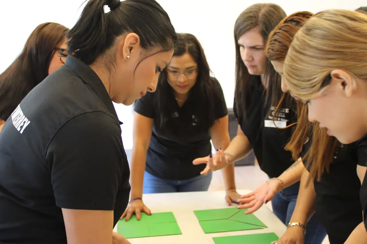 Grupo de profesionales concentrados en una actividad en interiores, diseñando estrategias juntos como parte del trabajo en equipo