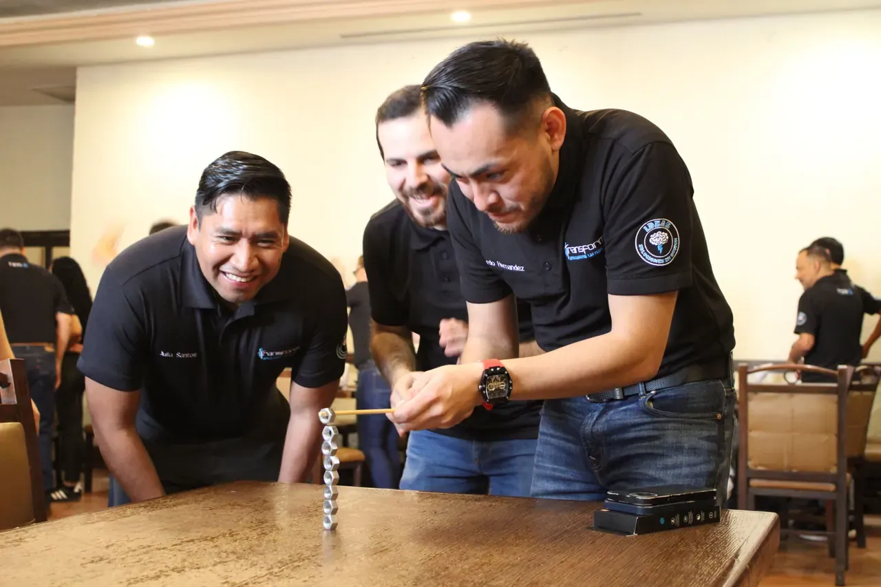 Participantes riendo mientras completan un desafío grupal, reflejando el impacto positivo de la unión del equipo