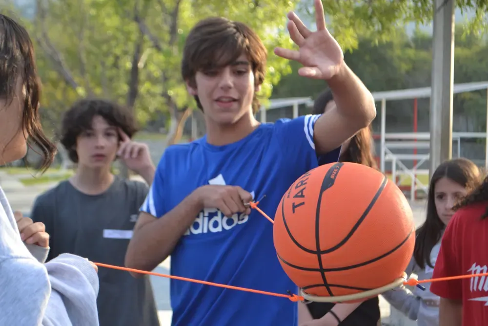 Campista en plena dinámica deportiva con un balón de basquetbol