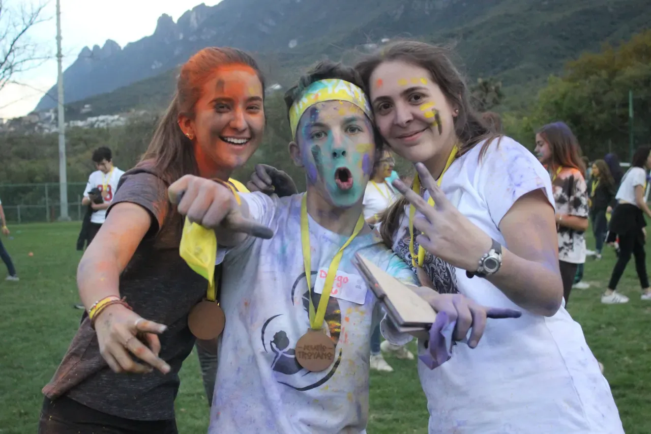 Grupo de estudiantes sonriendo con pintura en el rostro, celebrando la unión y la diversión en una actividad de integración