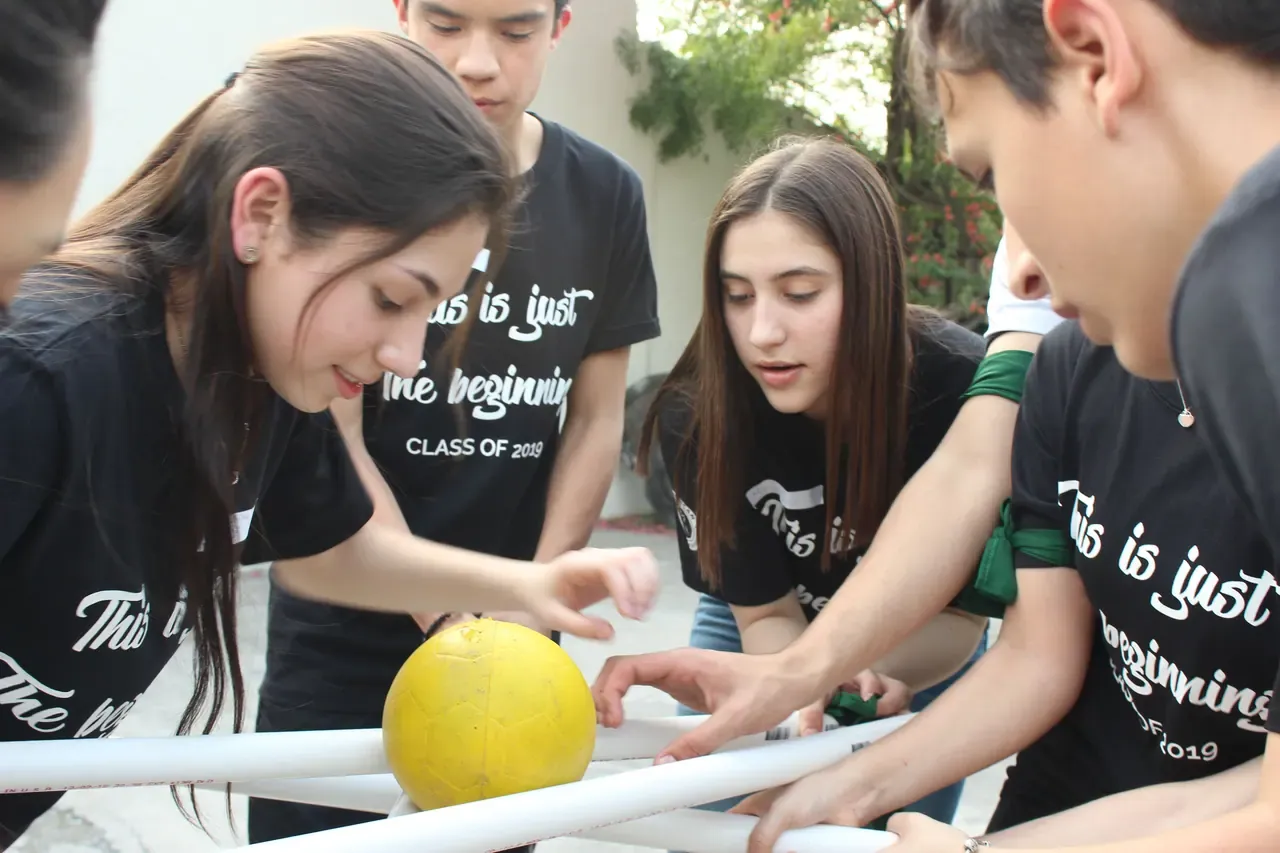 Estudiantes trabajando juntos en una actividad creativa, desarrollando vínculos y fortaleciendo la cooperación