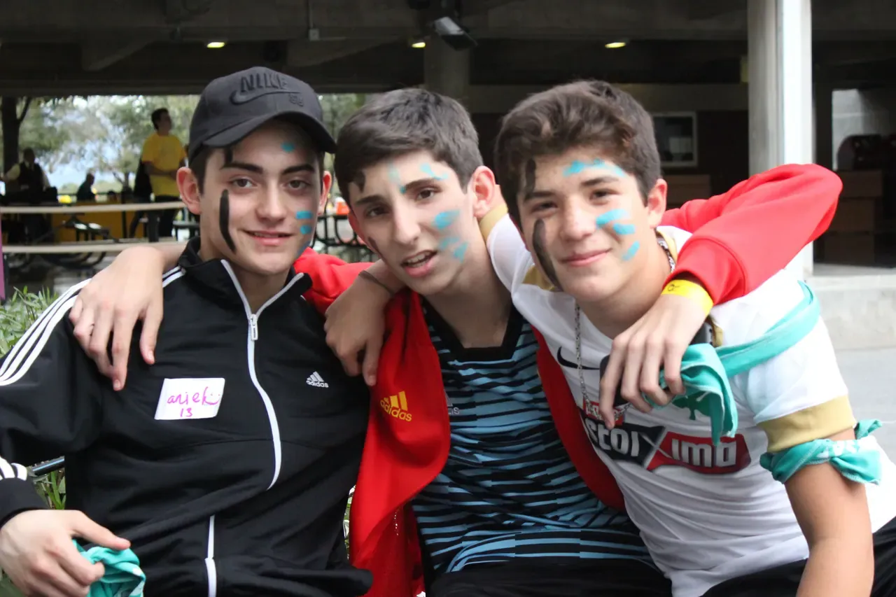 Estudiantes abrazándose y sonriendo después de una actividad, celebrando la unión creada durante el evento
