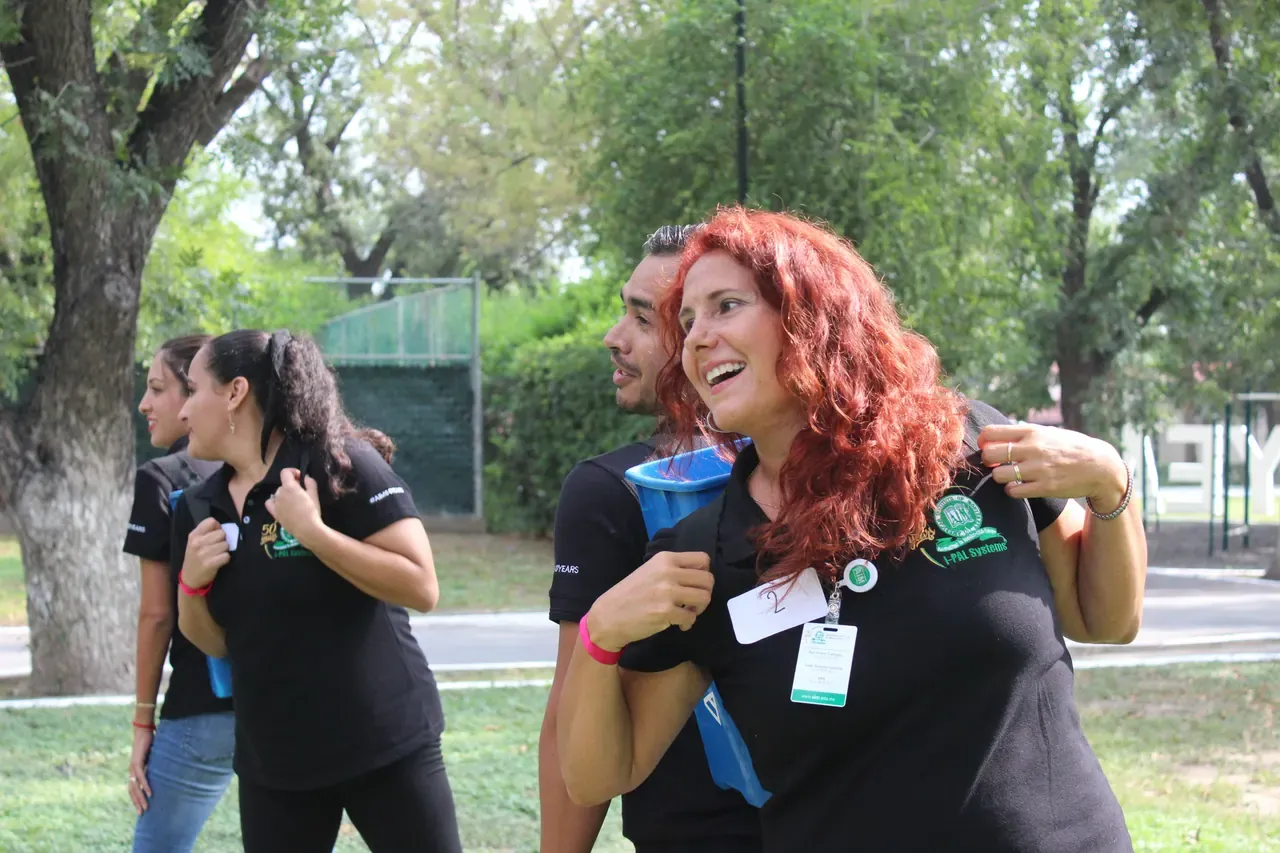 Dos maestros interactuando durante una dinámica al aire libre, promoviendo la confianza y la cooperación