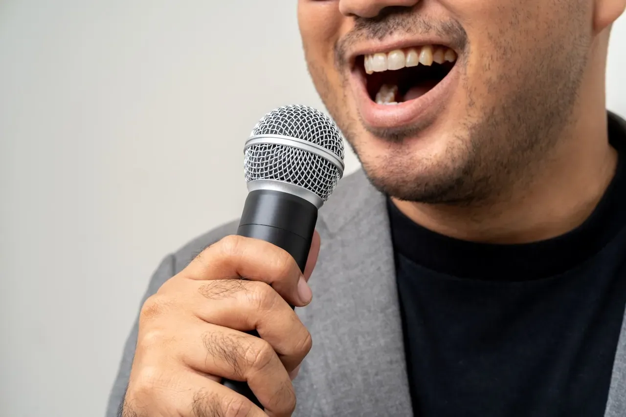 Primer plano de un ponente sonriendo mientras comparte un mensaje motivador, transmitiendo entusiasmo