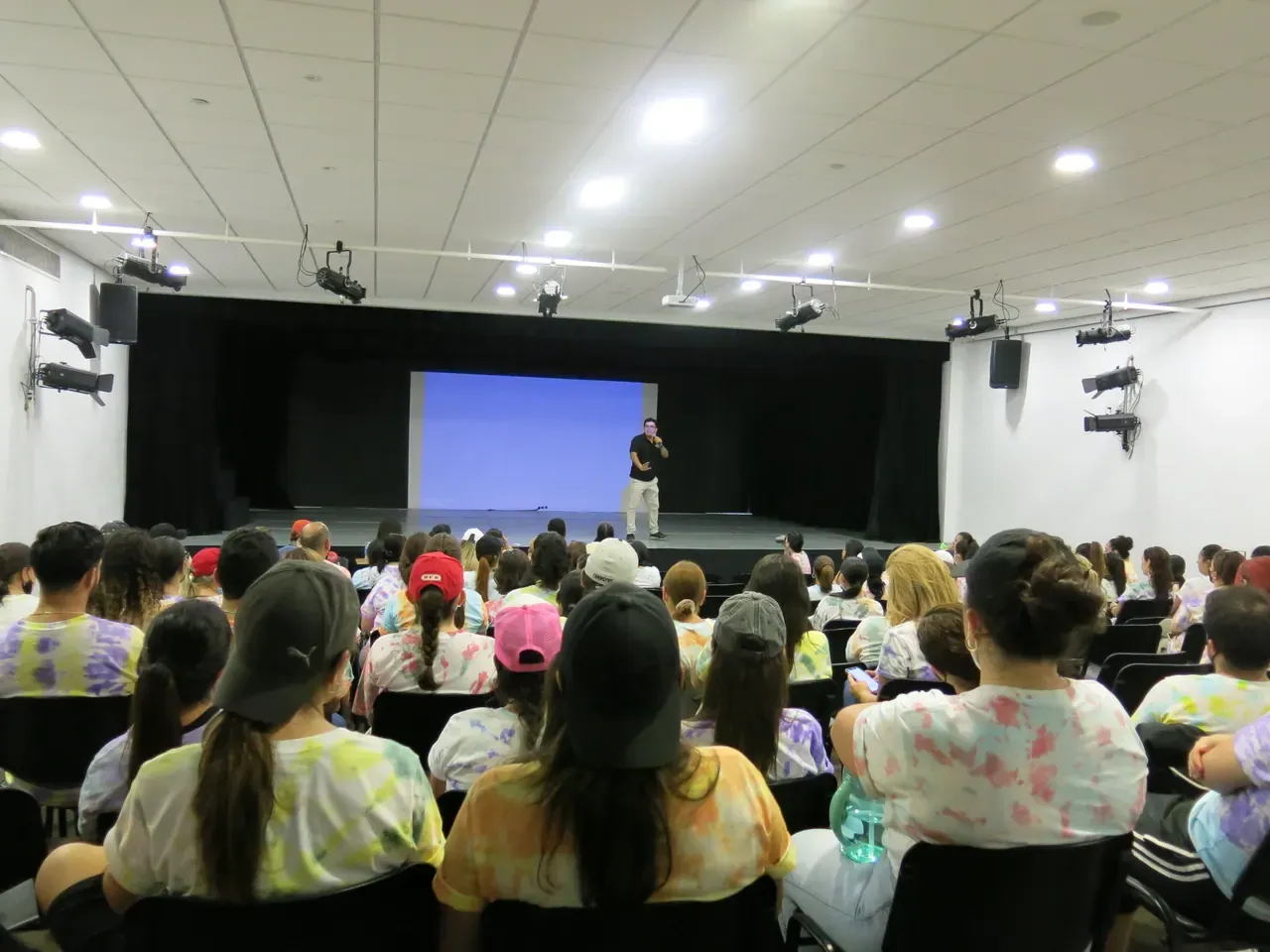 Vista trasera de una sala llena de participantes atentos durante una plática motivacional de ALYAX