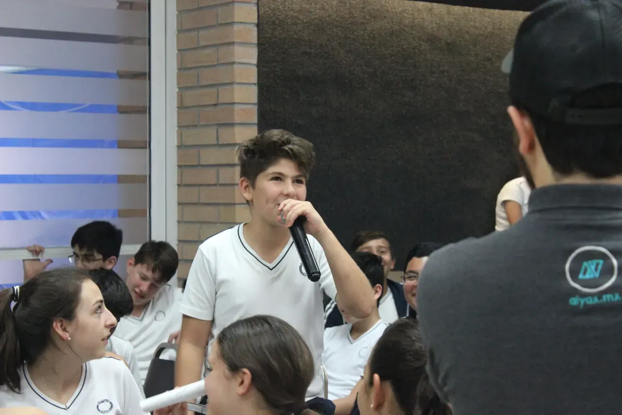 Joven reflexionando mientras escucha un mensaje inspirador en una plática motivacional, mostrando conexión con el contenido