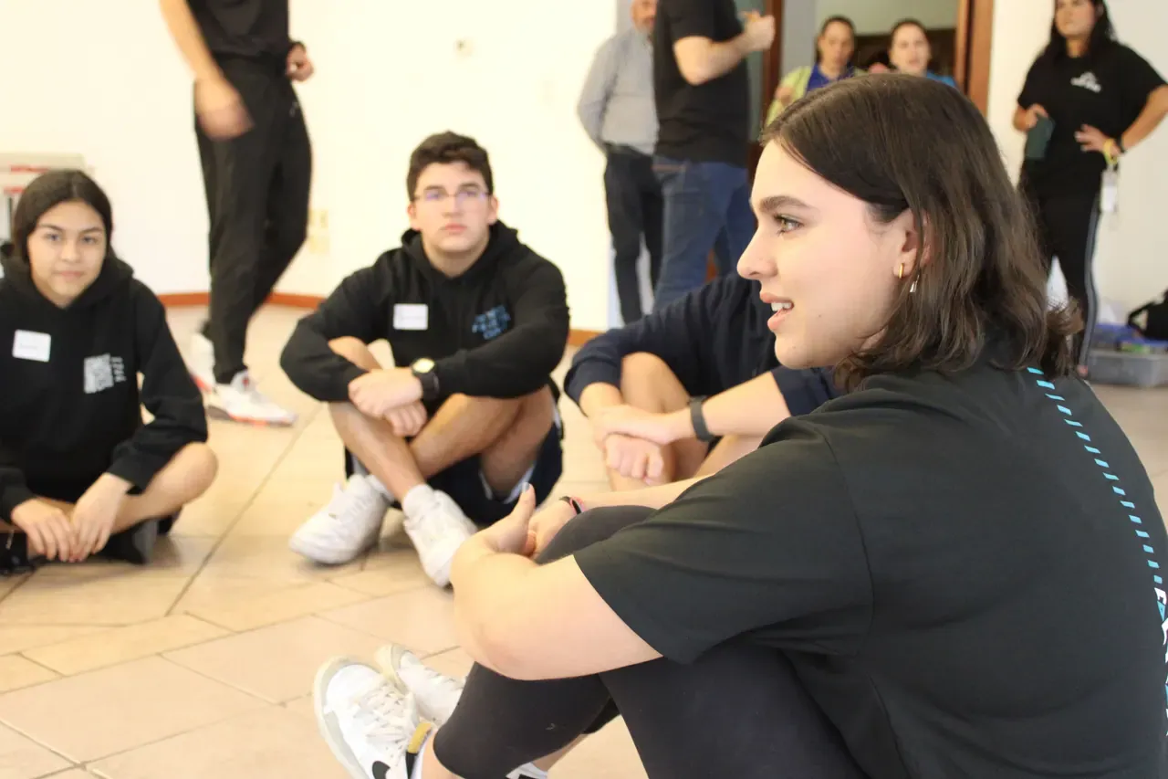 Participantes discutiendo ideas en una dinámica grupal, fomentando el intercambio de perspectivas motivadoras