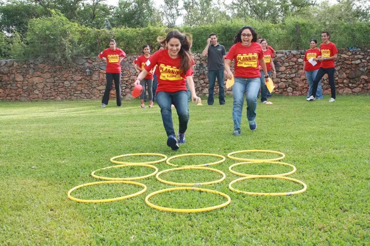 Participantes corriendo juntos hacia una meta, reflejando la energía y el espíritu competitivo del rally empresarial