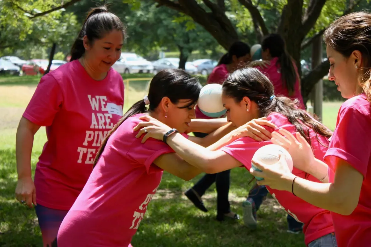 Participantes con playeras rosas en una dinámica de team building al aire libre